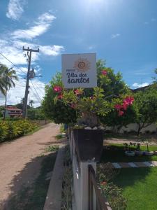 a sign for a villa disc gardens with flowers at Pousada Vila dos Santos in Porto De Galinhas
