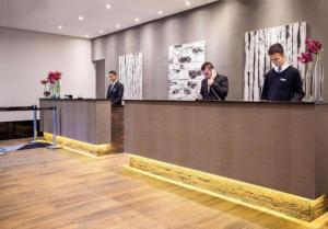 two men and a woman standing at a reception desk at Suíte 5 estrelas Hotel Av Ibirapuera 2534 Moema - 1 in Sao Paulo +39 photos