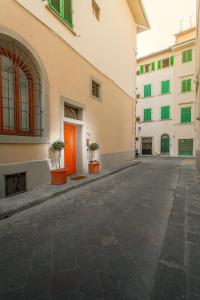 eine leere Straße mit einem Gebäude mit einer roten Tür in der Unterkunft Firenze Suite in Florenz