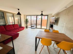 a living room with a red couch and yellow chairs at Zoela in Izola