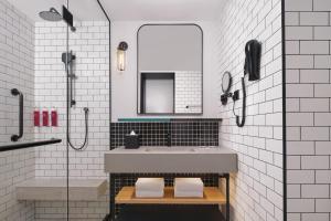 ein Badezimmer mit Waschbecken und Spiegel in der Unterkunft Moxy Putrajaya in Putrajaya