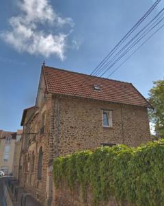 un bâtiment en briques avec une haie devant lui dans l'établissement Appartement Cosy, à Boissy-Saint-Léger