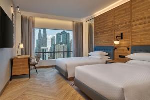 um quarto de hotel com duas camas e uma grande janela em Four Points by Sheraton Kuala Lumpur, City Centre em Kuala Lumpur