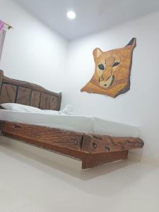 a wooden bed with a cat pillow on a wall at HOTEL EL EMPERADOR in Doradal