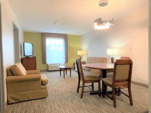 a living room with a table and chairs and a television at Holiday Inn Express & Suites Sulphur - Lake Charles, an IHG Hotel in Sulphur