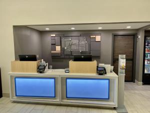 een lobby met een balie met twee laptops erop bij Holiday Inn Express & Suites Sulphur - Lake Charles, an IHG Hotel in Sulphur