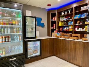 a store counter with an open refrigerator and drinks at Holiday Inn Express & Suites Sulphur - Lake Charles, an IHG Hotel in Sulphur
