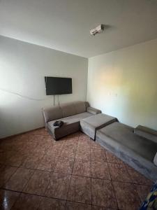 a room with a couch and a flat screen tv at Residencial Berakah in Rio Verde