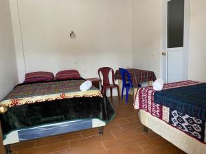 1 Schlafzimmer mit 2 Betten, einem Tisch und Stühlen in der Unterkunft “Posada Vicentas” compartir con una familia Tz’utujil in San Juan La Laguna