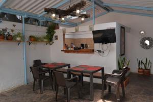 Cette chambre dispose de 2 tables, de chaises et d'une télévision à écran plat. dans l'établissement Casa Noche Azul alojamiento turístico en Villa de Leiva, à Villa de Leyva