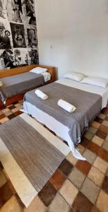 two beds sitting next to each other in a room at Suítes da Praça Tiradentes in Tiradentes