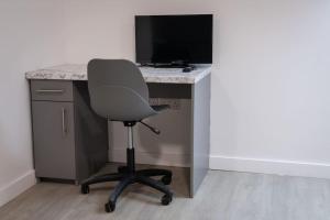 a computer desk with a monitor and a chair at Stylish Central One Bed Studio in Manchester