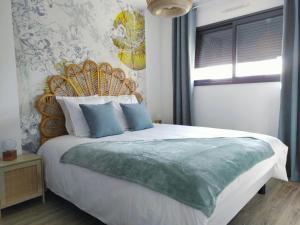 una camera da letto con un grande letto con cuscini blu di Charming cottage only 8 minutes from Etretat a Bordeaux-Saint-Clair