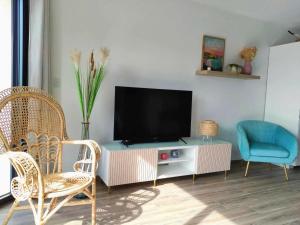 a living room with a tv and two chairs at Gîte in Etretat near Cliffs & Beach in Bordeaux-Saint-Clair