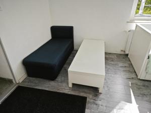 Smart Appart في كولونيا: أريكة سوداء وطاولة بيضاء في الغرفة