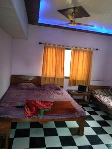 a bedroom with a bed and a checkered floor at Advait Holiday Home in Nagaon