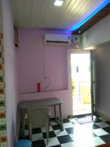 um quarto com uma mesa, um banco e uma janela em Advait Holiday Home em Nagaon