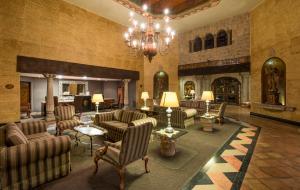 a lobby with couches and chairs and a chandelier at Quinta Real Aguascalientes in Aguascalientes