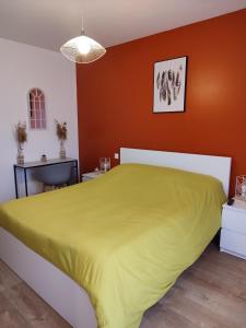 Schlafzimmer mit gelbem Bett und orangefarbenen Wänden in der Unterkunft La Rose Paisible in Brusson