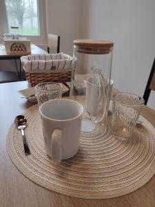 a table with cups and glasses on a table at La Rose Paisible in Brusson