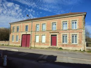 a brick building with red doors on a street at La Rose Paisible in Brusson