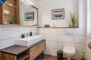 a bathroom with a sink and a toilet at 257 Haus Otto in Ahlbeck +20 photos