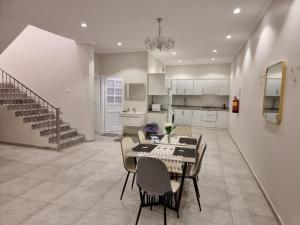 a dining room with a table and chairs and a kitchen at فلل شدا ورقان بالهدا in Al Hada