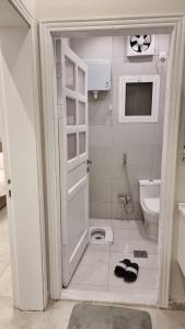 a bathroom with a shower and a toilet and a door at فلل شدا ورقان بالهدا in Al Hada