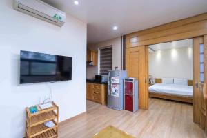 a room with a kitchen with a refrigerator and a bed at Cindy Hotel & Apartments - Khách Sạn Căn Hộ ở Trung Tâm TP Hải Phòng in Hai Phong
