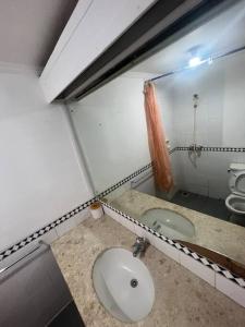 Baño con 2 lavabos y espejo en Apartemen carita Anyer view laut en Carita