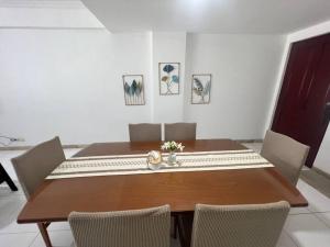 comedor con mesa de madera y sillas en Apartemen carita Anyer view laut en Carita