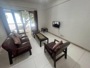 una sala de estar con sofás y TV. en Apartemen carita Anyer view laut, en Carita