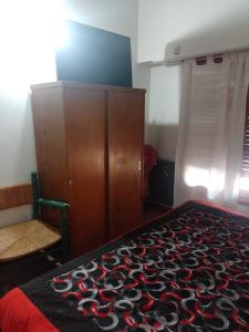 um quarto com uma cama e um armário de madeira em La Soñada em Tandil