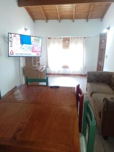 una sala de estar con una gran mesa de madera y un sofá en La Soñada en Tandil