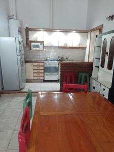 cocina con mesa y nevera blanca en La Soñada en Tandil