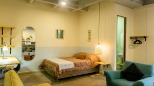 ein Schlafzimmer mit einem Bett und einem blauen Stuhl in der Unterkunft Casa Selva in Medellín