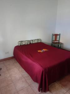 a bed with a red blanket on top of it at La Soñada in Tandil