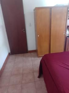 1 dormitorio con cama morada y armarios de madera en La Soñada en Tandil