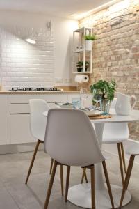 uma cozinha com uma mesa branca e cadeiras em BLUE HOUSE A casa di Tatta - apartments by the sea em Francavilla al Mare