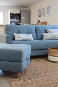 um sofá azul e uma cadeira numa sala de estar em BLUE HOUSE A casa di Tatta - apartments by the sea em Francavilla al Mare
