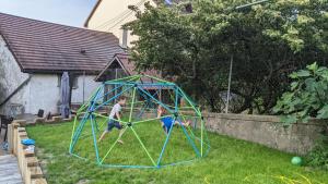dos niños jugando en una telaraña en un patio en Grand appart 115m² avec jardin+parking proche gare en Bellegarde-sur-Valserine