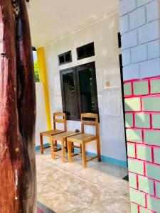 2 sillas de madera y una mesa en una habitación en Breeze Hostel en Kuta Lombok