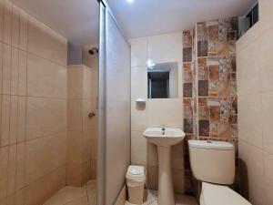 y baño con aseo, lavabo y ducha. en Illari Wari II-Hotel Sauna, en Ayacucho