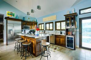 a kitchen with a island with bar stools at Luxury Villa, Perfect for Groups. Stunning Pool. Allamanda del Mar in Placencia Village