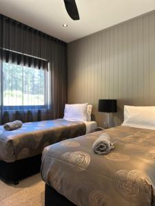 a hotel room with two beds and a window at Kangaroo Valley Golf and Country Retreat in Kangaroo Valley