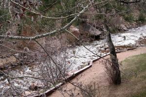 een rivier met sneeuw op de grond en een boom bij Fawn Valley Inn- 226 condo in Estes Park