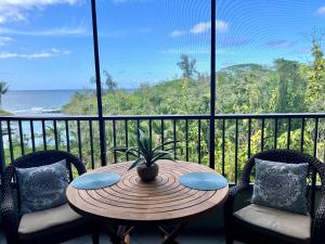 a table and chairs on a balcony with a view of the ocean at Direct Oceanfront Mauna Loa Shores Honu Elua #508 next to Carlsmith Beach park, Hilo HI in Hilo
