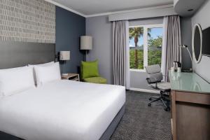 肯普顿帕克Holiday Inn Johannesburg OR Tambo Airport Hotel by IHG的一间带床、书桌和窗户的酒店房间