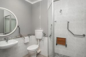 肯普顿帕克Holiday Inn Johannesburg OR Tambo Airport Hotel by IHG的配有马桶、水槽和镜子的浴室