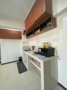 a kitchen with a counter with a microwave and a refrigerator at The Penthouse Suite in Pusok